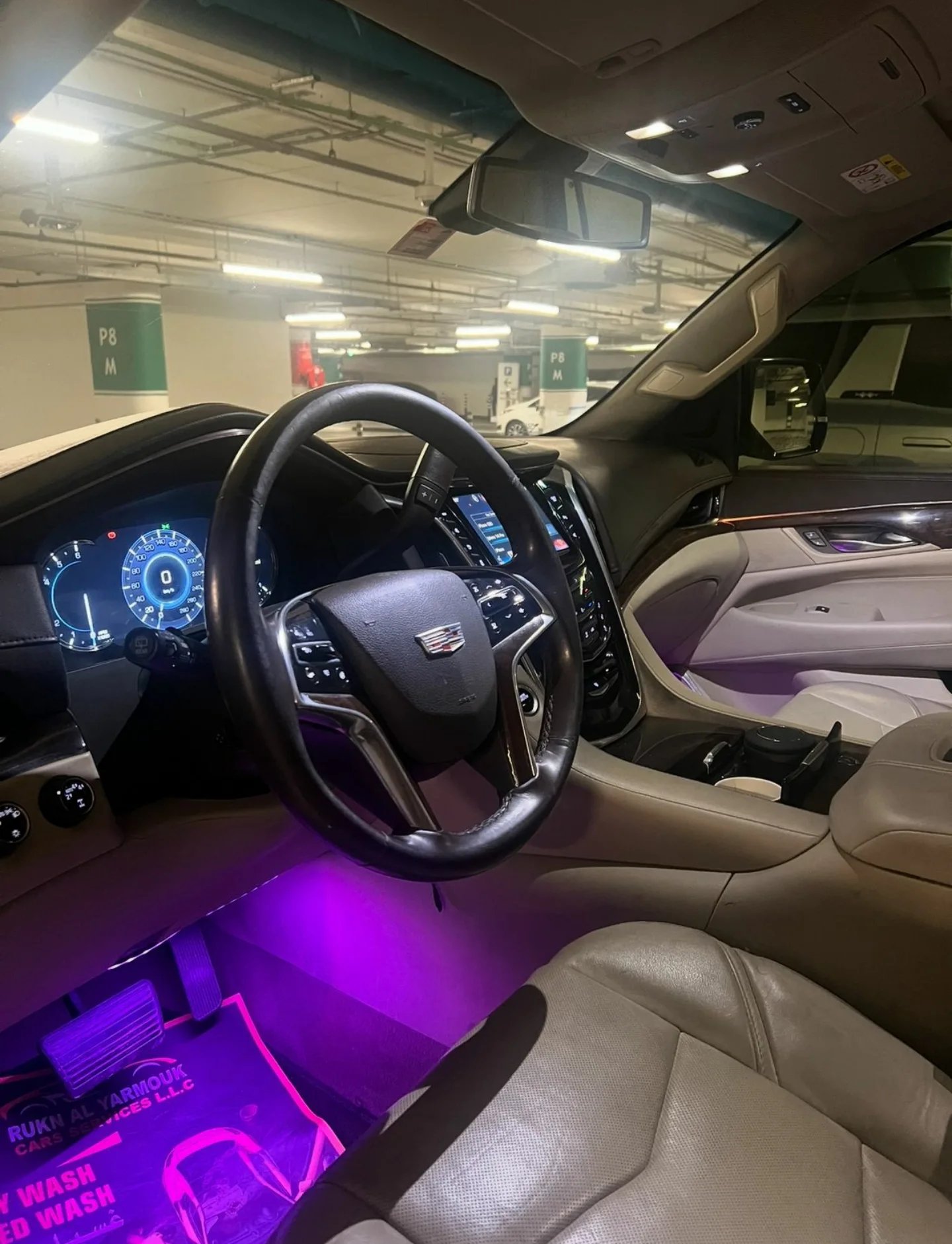Interior of a car, specifically the driver's seat and dashboard. The car appears to be a luxury sedan with a sleek and