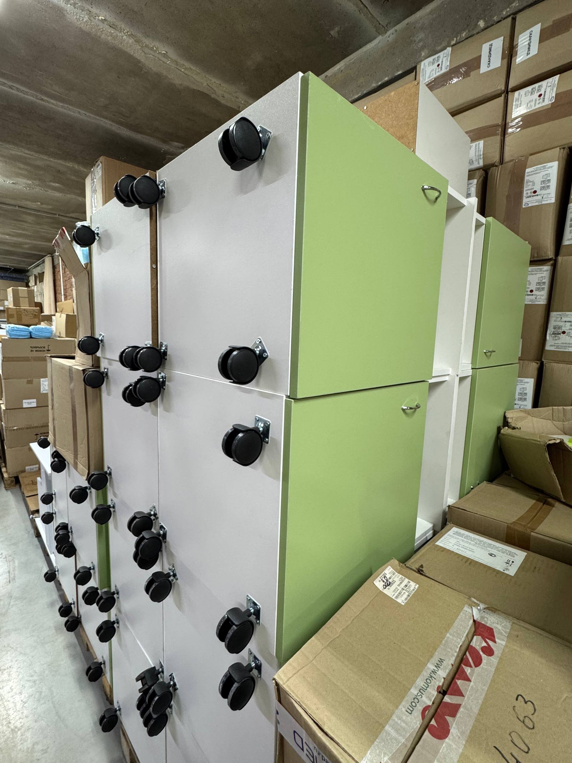 Large white and green metal cabinet with multiple black knobs on the front. The cabinet appears to be in a warehouse or