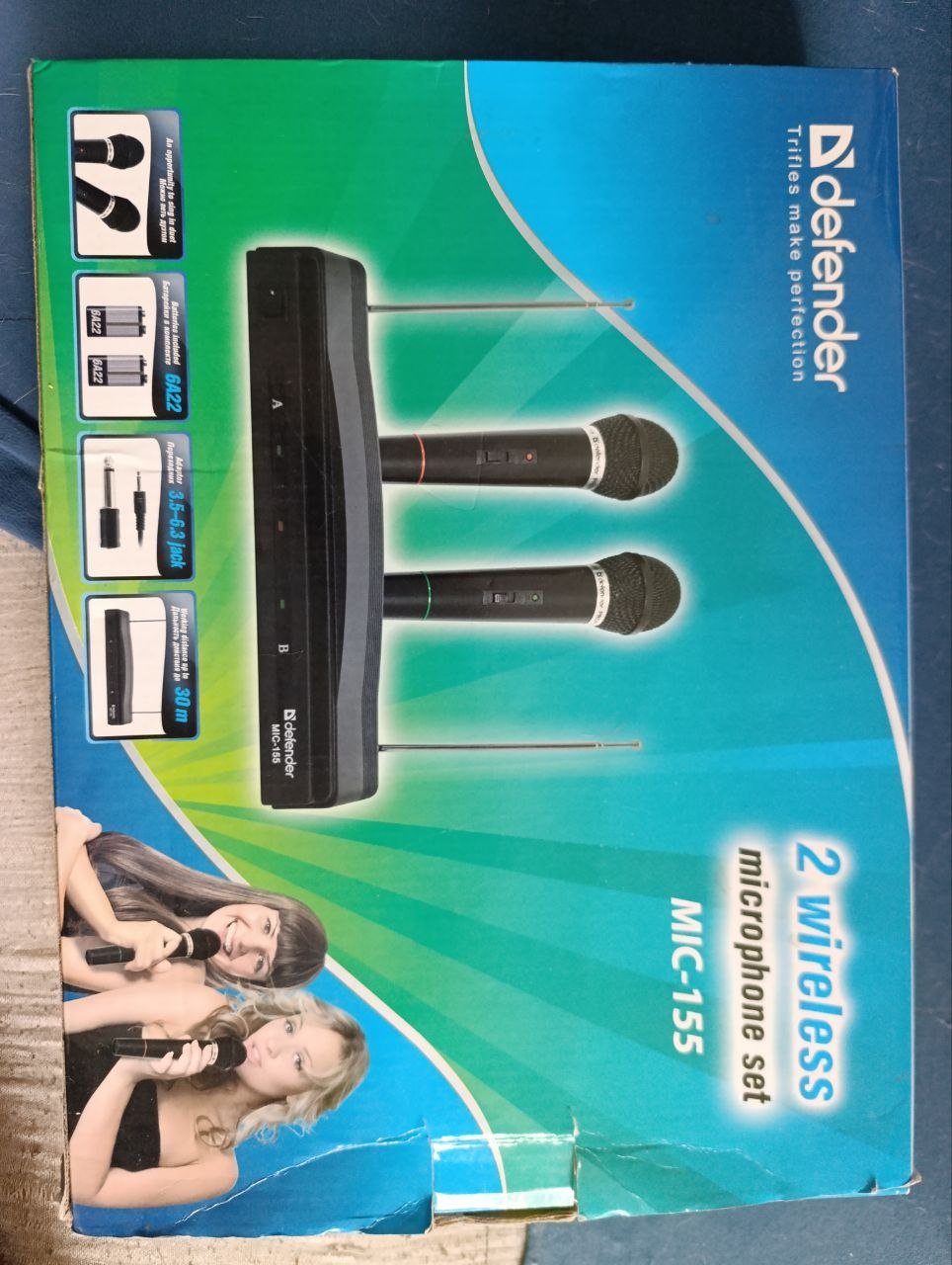 Product packaging for a microphone set. The packaging is blue and green in color with the brand name "Defender" written in