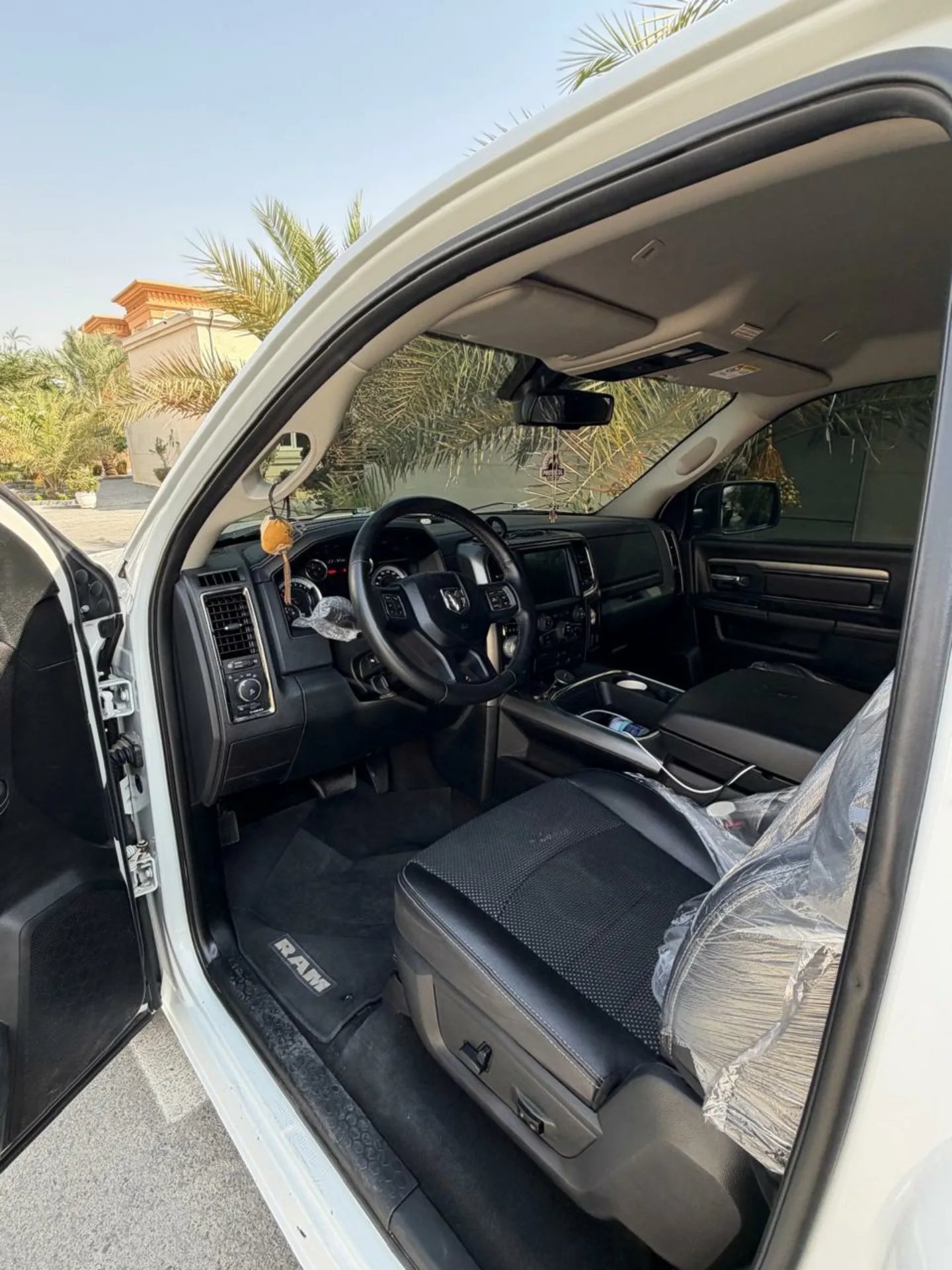 Interior of a white pickup truck with the door open. The interior of the truck is clean and well-maintained, with black