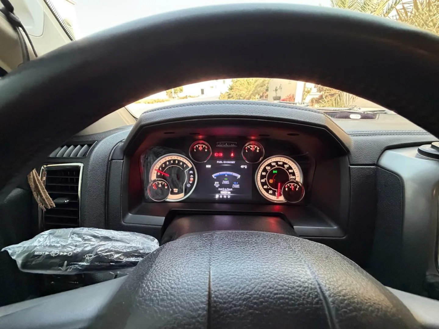 Dashboard of a car, specifically the instrument cluster. The dashboard is black and has a digital display in the center. The