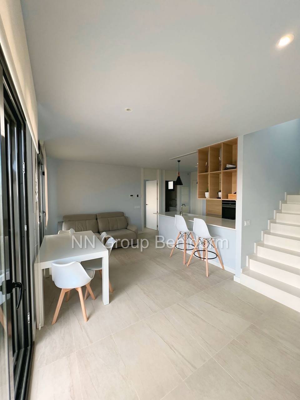 Modern and spacious living and dining area in a modern apartment. The room has a white ceiling with recessed lighting and a