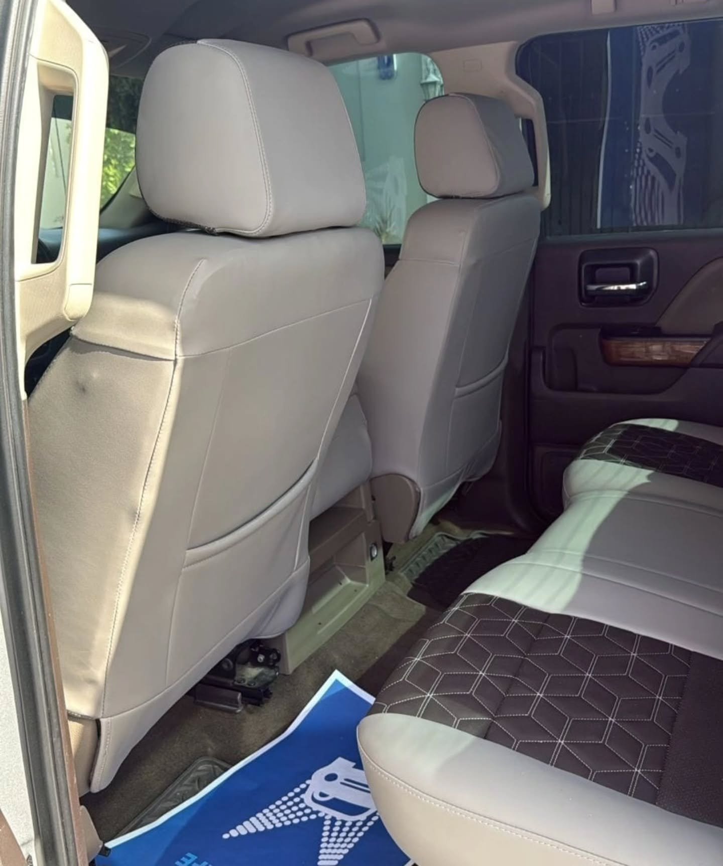Interior of a car, specifically the back seats. The seats are beige in color and appear to be made of leather. The back