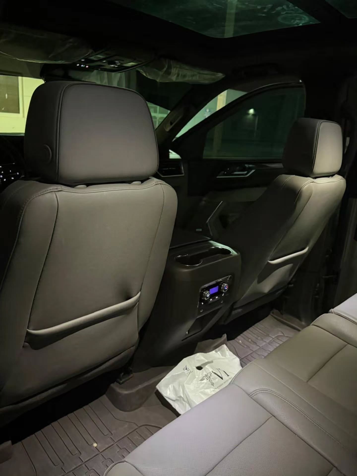 Interior of a car, specifically the back seats. The seats are upholstered in a light grey leather and have a modern design.