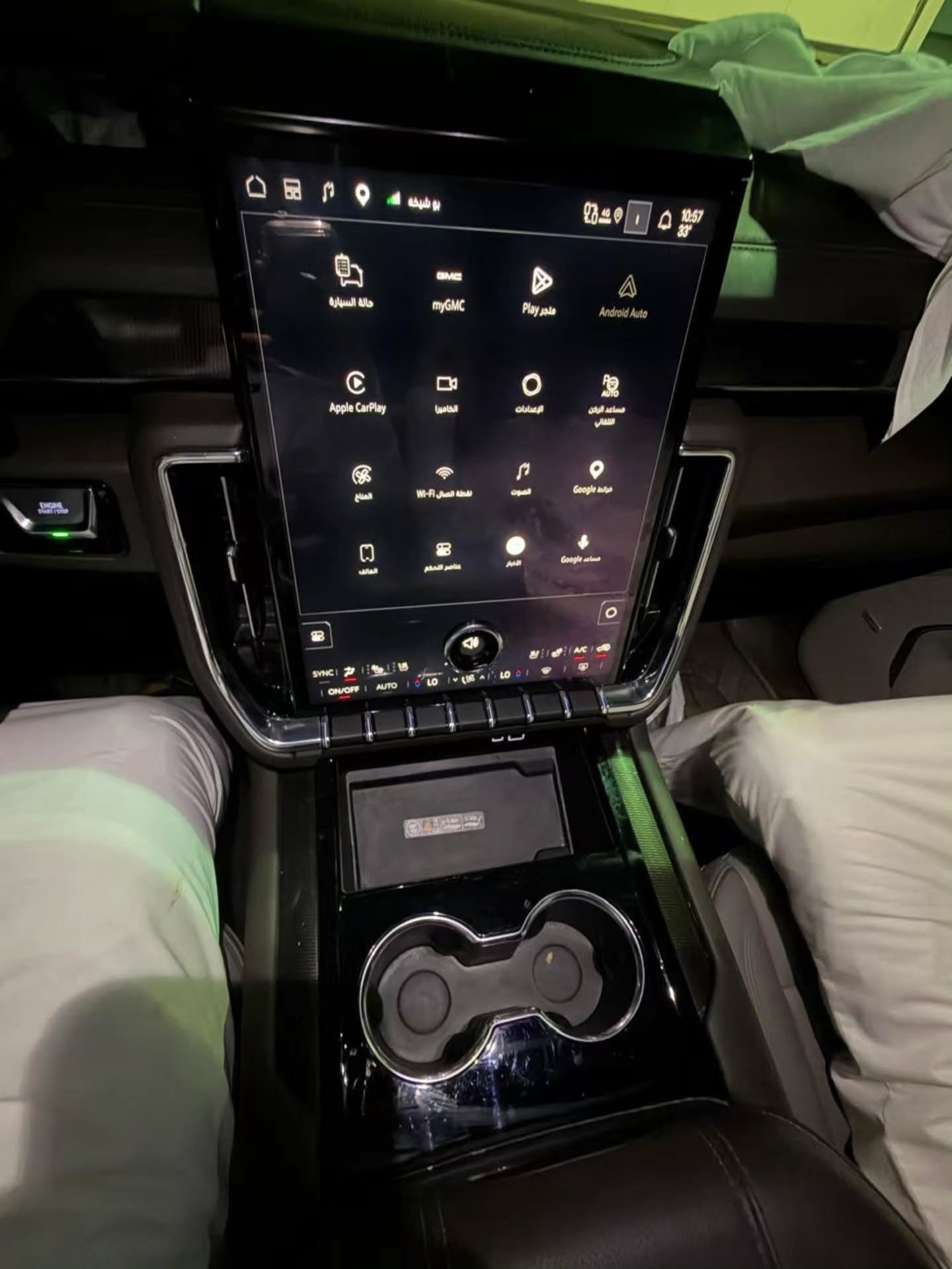 Interior of a car, specifically the center console. The console is black and has a large touch screen display in the center.