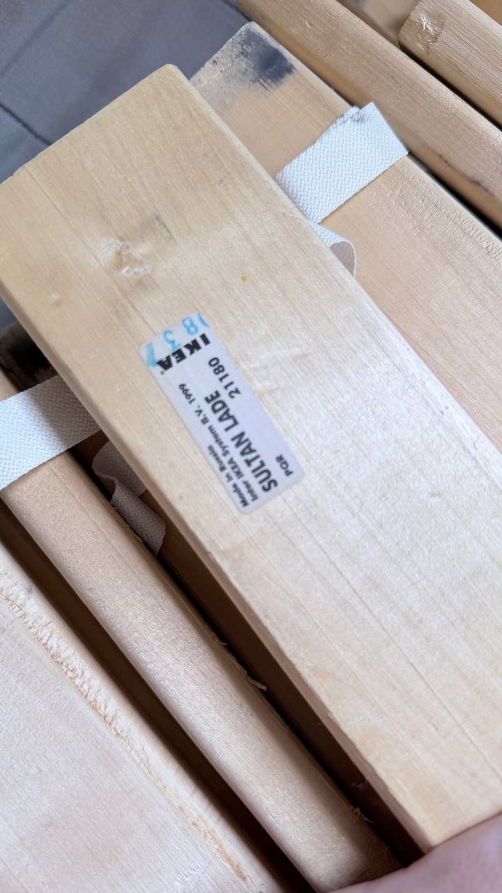 Stack of wooden planks. The planks are light brown in color and appear to be made of a light-colored wood. They are stacked