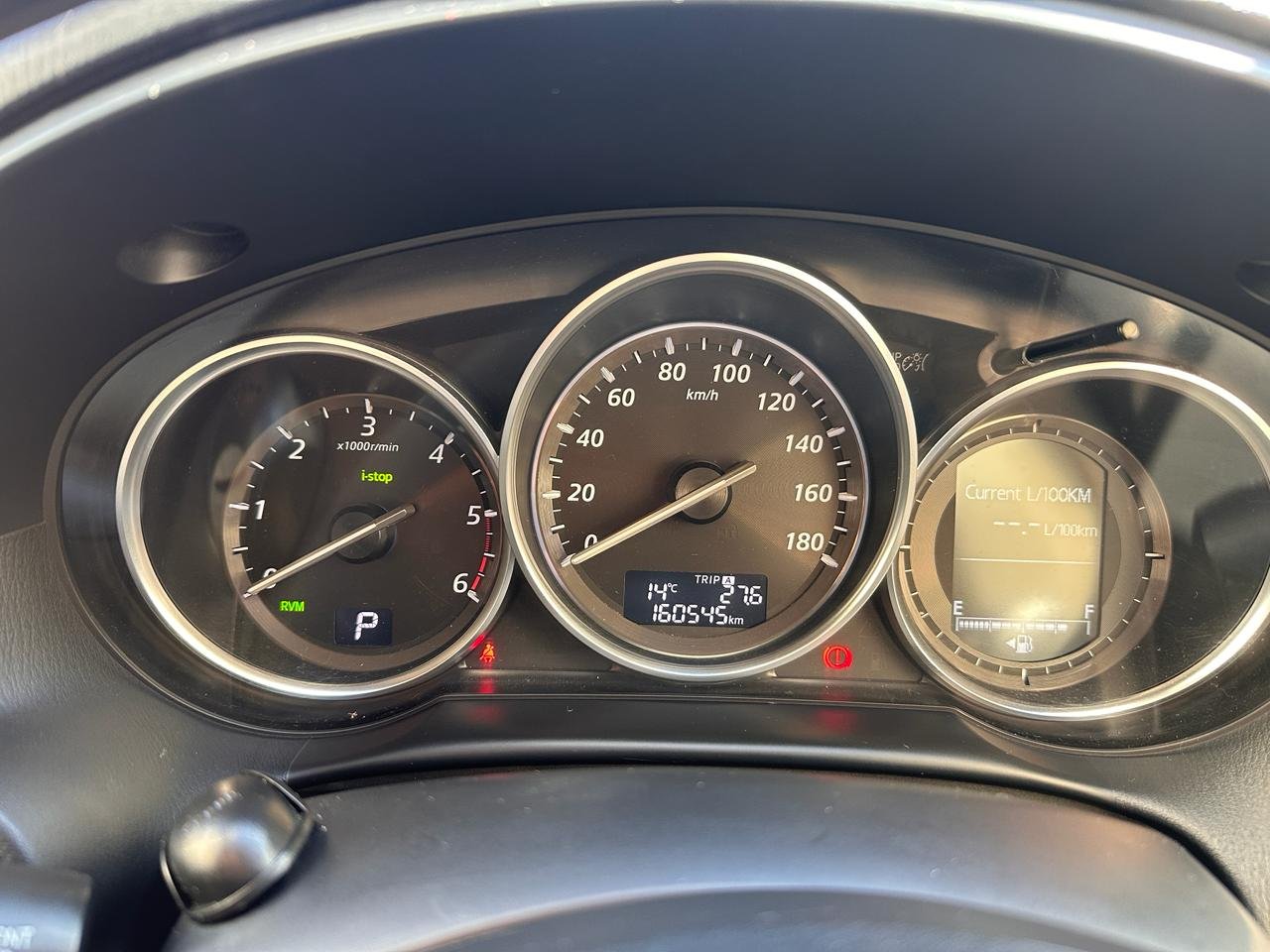 Dashboard of a car, specifically the instrument cluster. There are three circular gauges in the center of the image, each