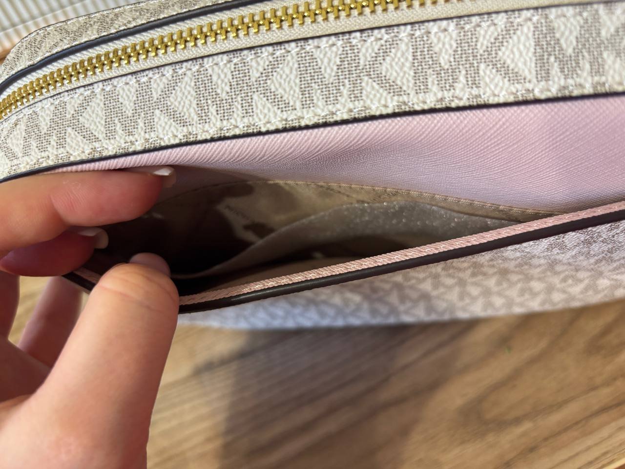 Close-up of a person's hand holding a zipper. The zipper is open and the person is holding it open, revealing the interior