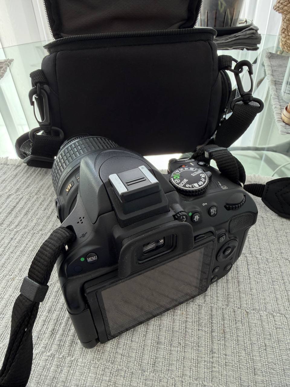 Nikon DX DSLR camera with a 24-70mm f/2.8 lens attached to it. The camera is black in color and has a strap attached to the
