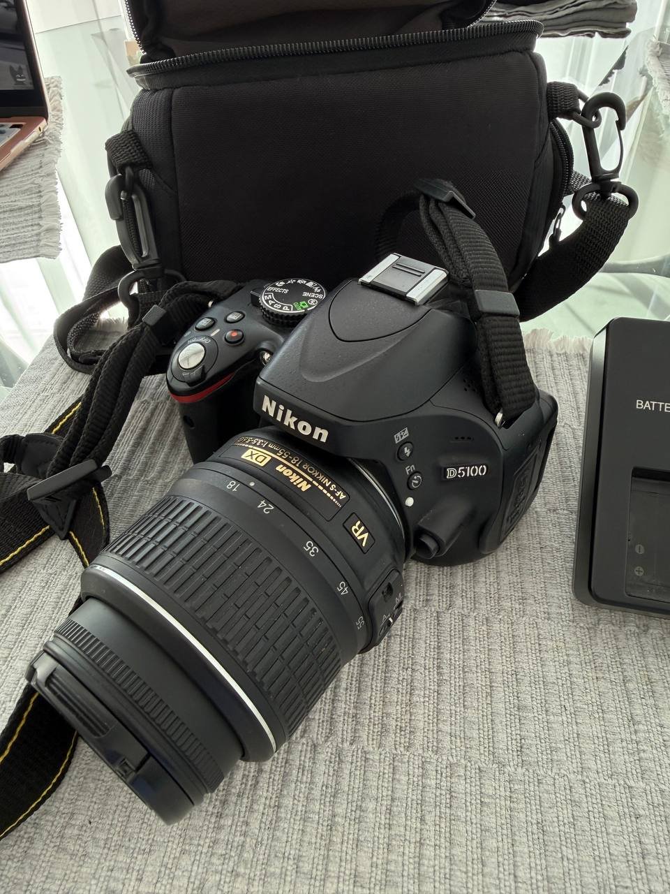 Nikon DSLR camera with a large lens attached to it. The camera is black in color and has the brand name "Nikon" written on
