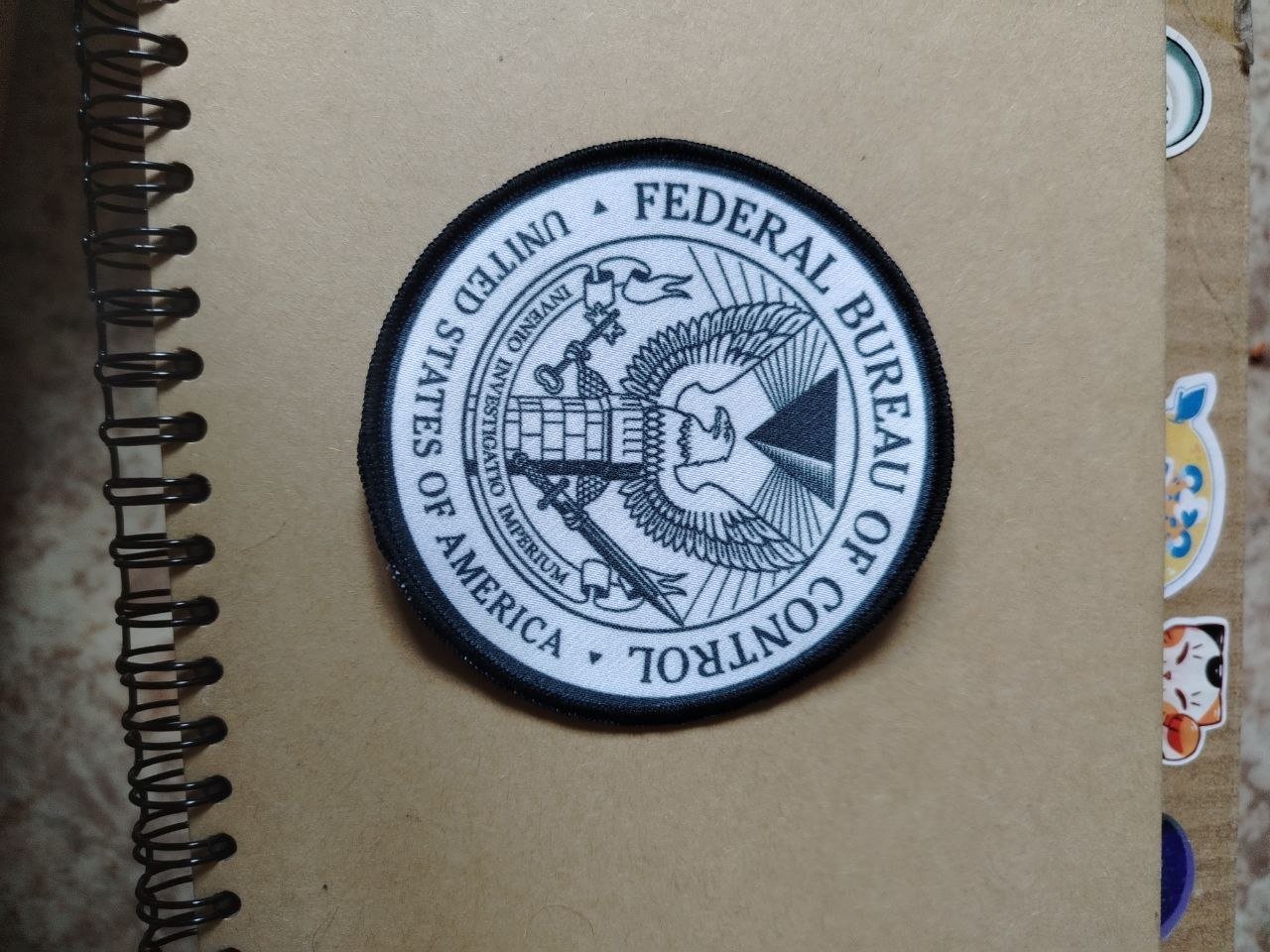 Close-up of the seal of the United States Federal Bureau of Control. The seal is circular in shape and has a black