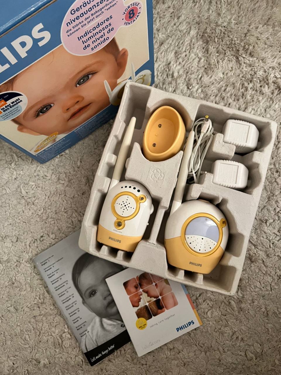 Philips baby monitor in its packaging. The packaging is a blue cardboard box with a picture of a baby's face on the front