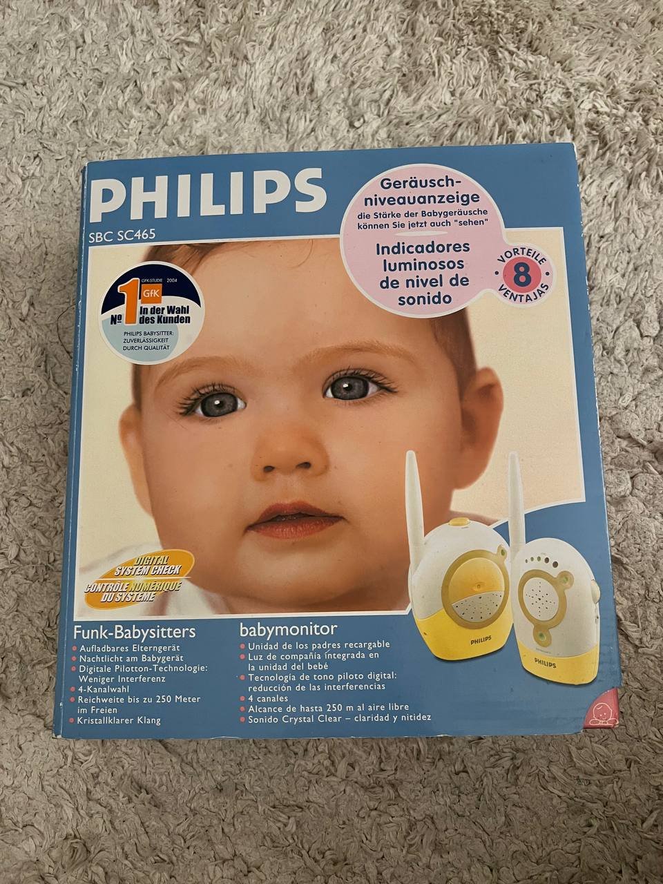 Philips baby monitor product. The packaging is a blue cardboard box with a picture of a baby's face on the front. The baby