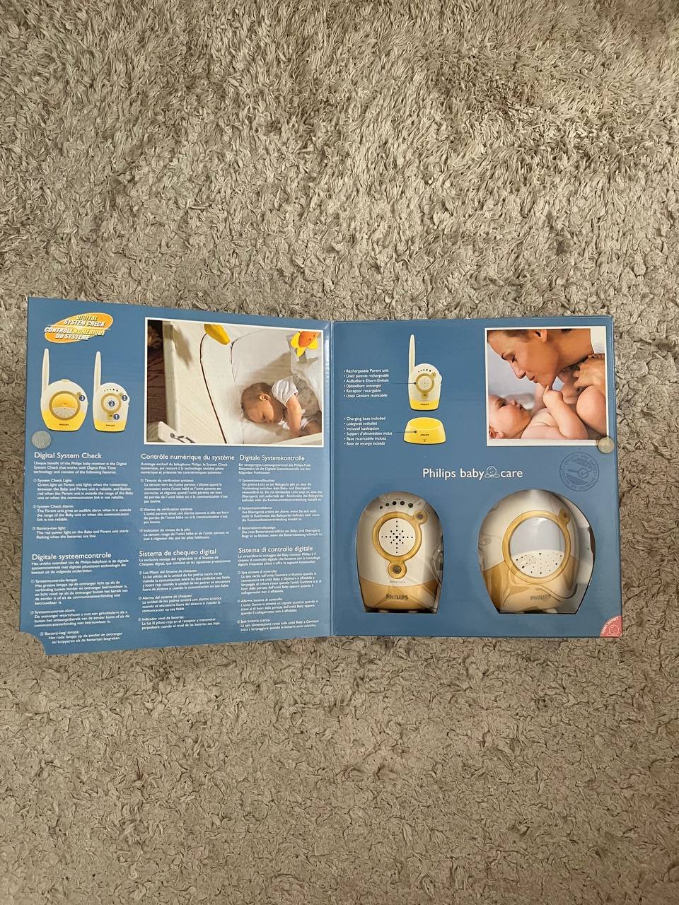Philips baby care product brochure. The brochure is lying on a beige carpeted floor. The cover of the brochure has a blue