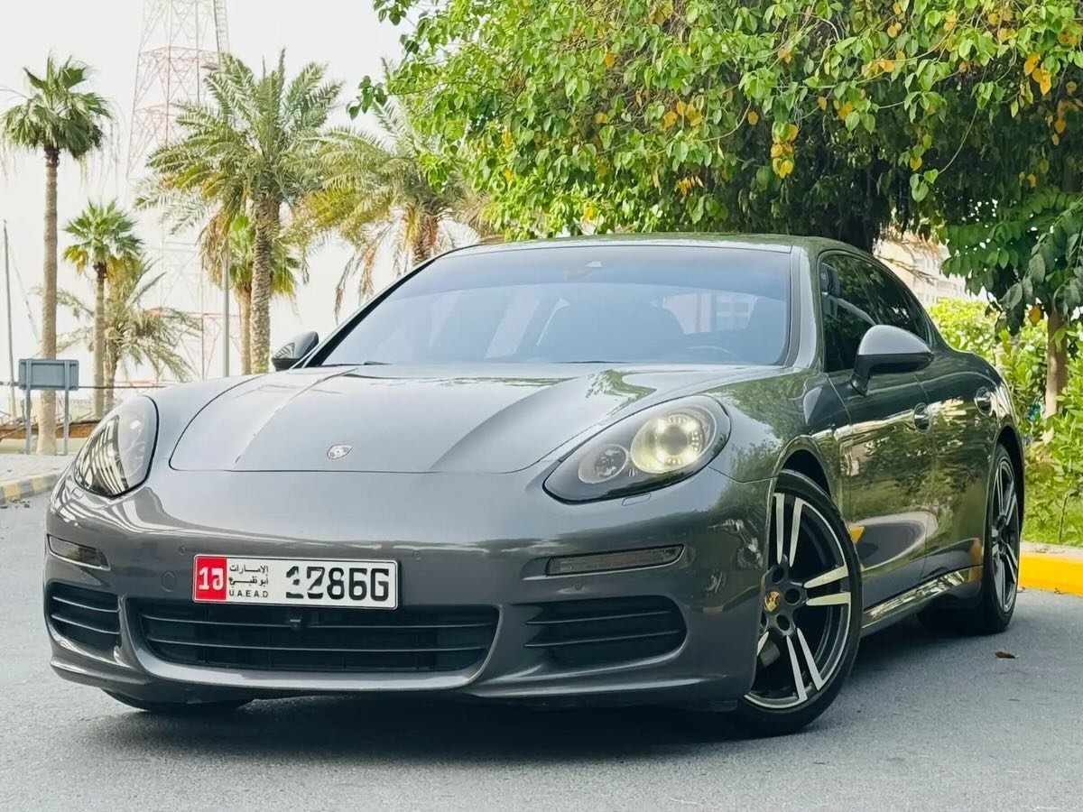 Grey Porsche Panamera parked on the side of a road. The car is a two-door coupe with a sleek and modern design. It has a