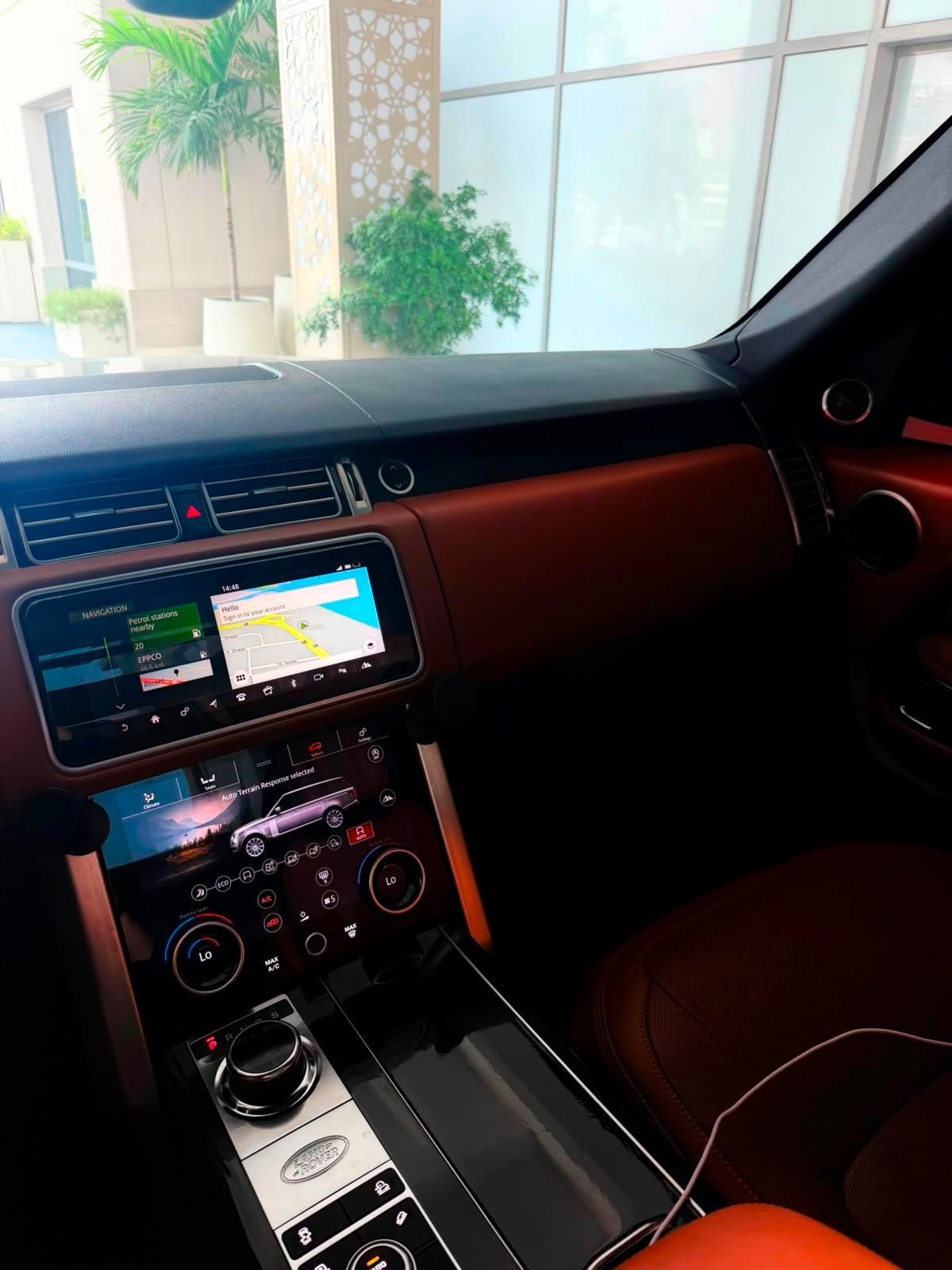Interior of a car, specifically the dashboard and the center console. The dashboard is black and has a large touch screen