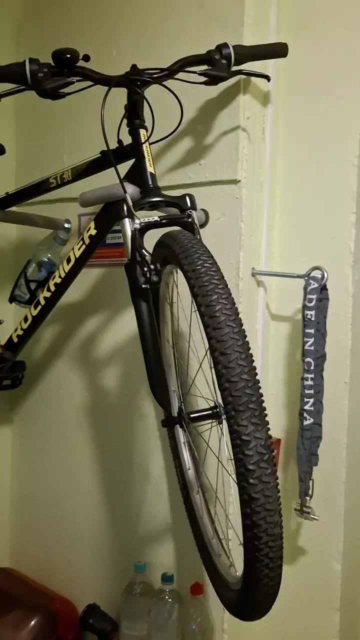 Black and yellow mountain bike hanging on a wall. The bike has a black frame with the word "RockShox" written on it in white