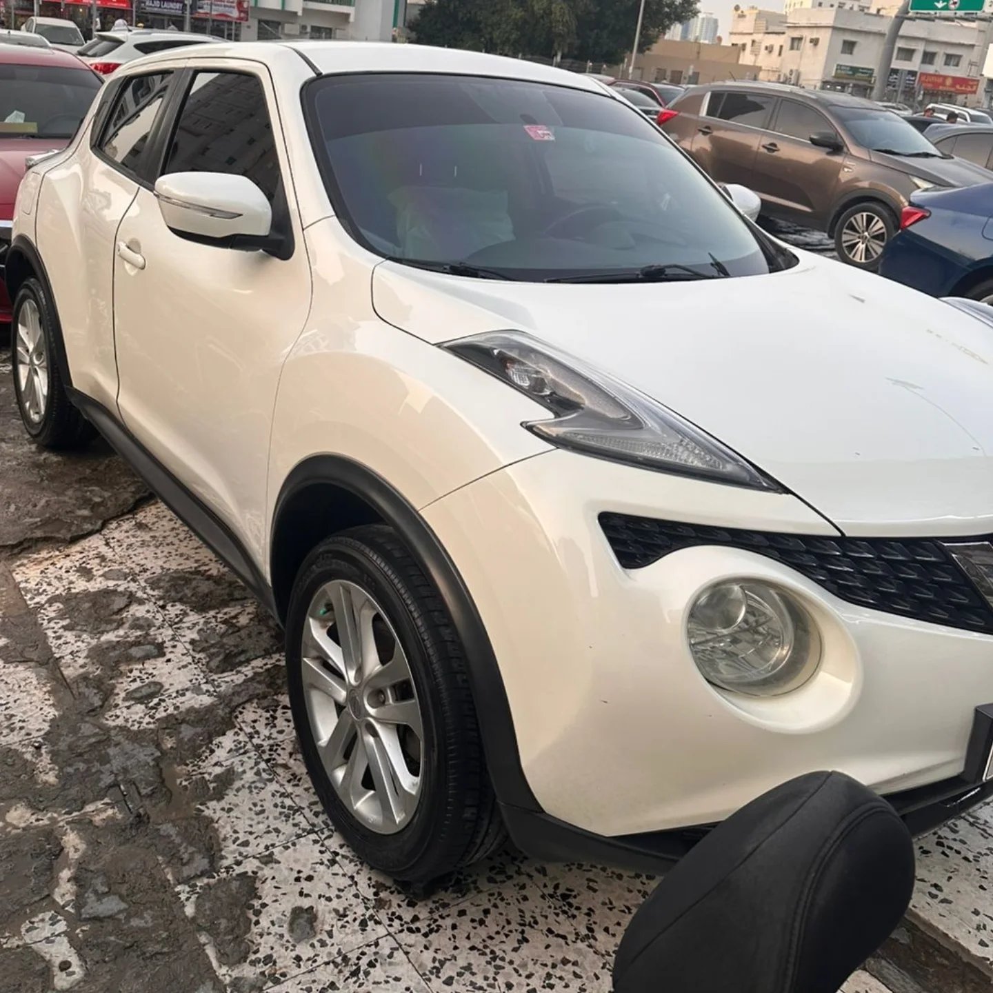 White Nissan Juke SUV parked in a parking lot. The car is facing towards the left side of the image and is positioned in the