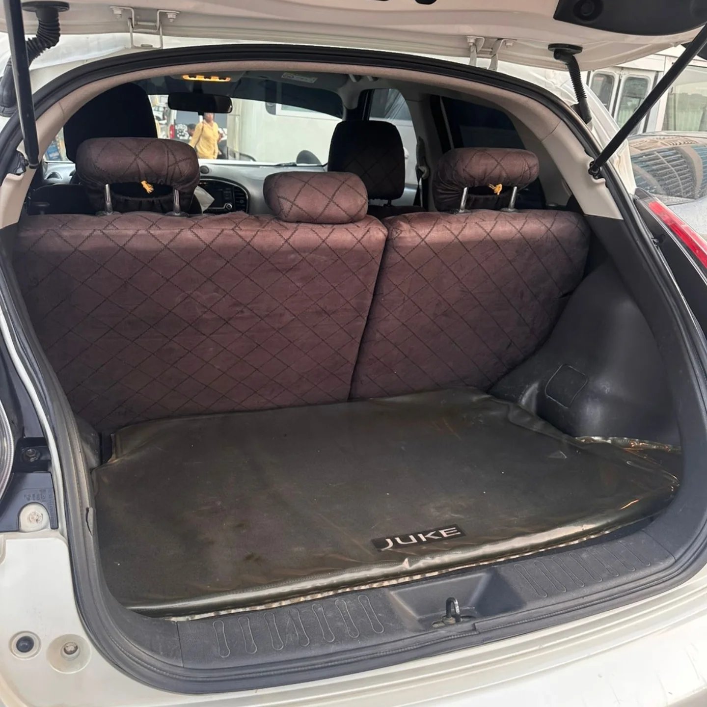 Trunk of a car with the back seats folded down. The trunk is open and the interior of the car is visible. The seats are